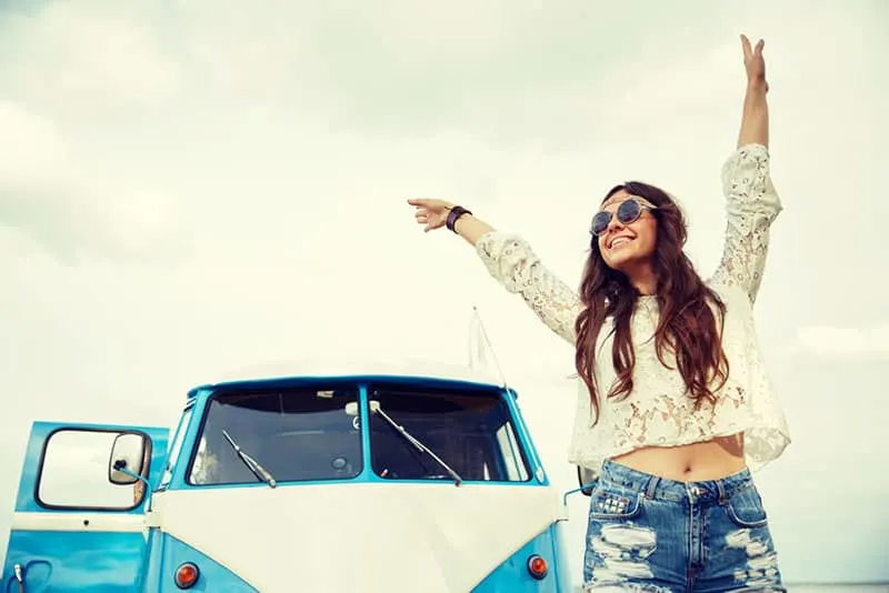 happy hippie woman standing by the van