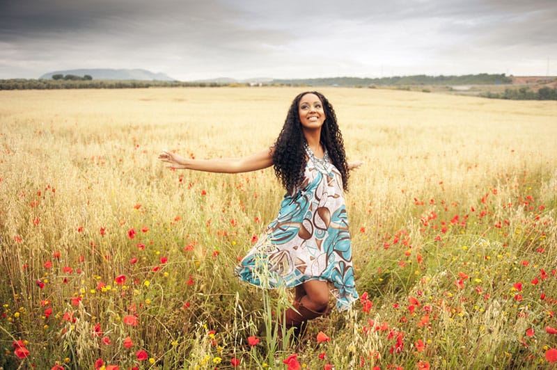 mulher feliz a caminhar pelo campo