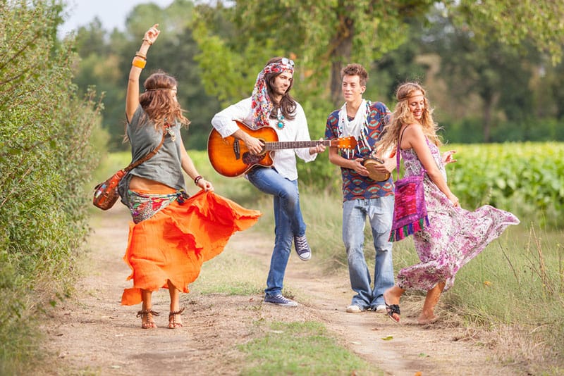 grupo hippie tocando música y bailando