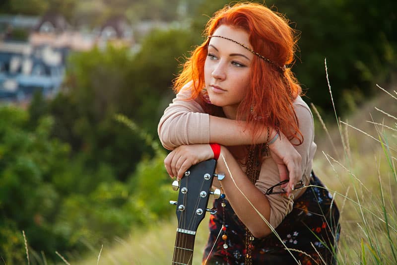 Mulher hippie a posar com uma guitarra