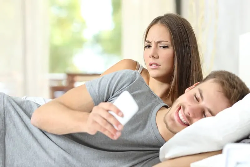 jealous woman looking at man phone