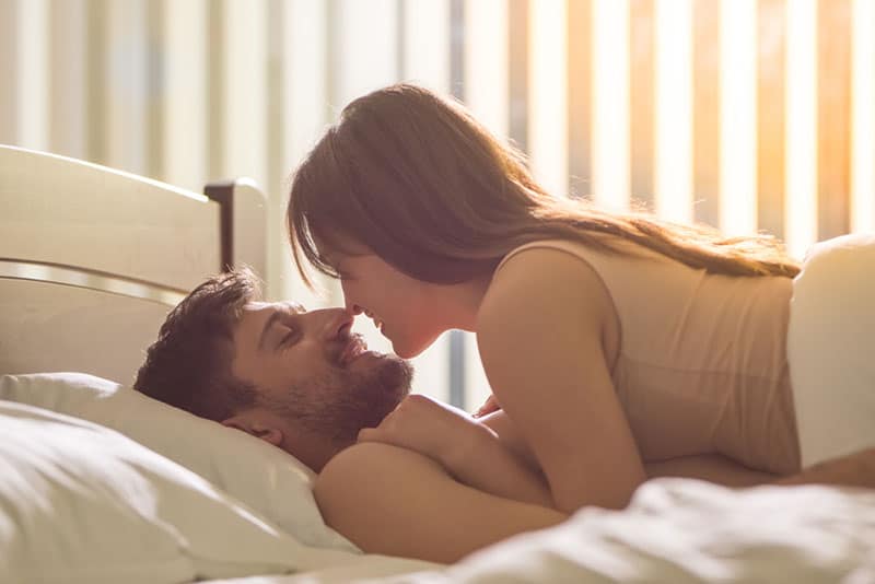 lovely couple lying on bed and looking each other