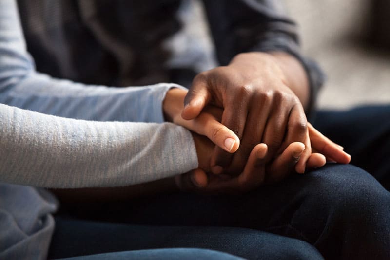 hombre y mujer cogidos de la mano en casa