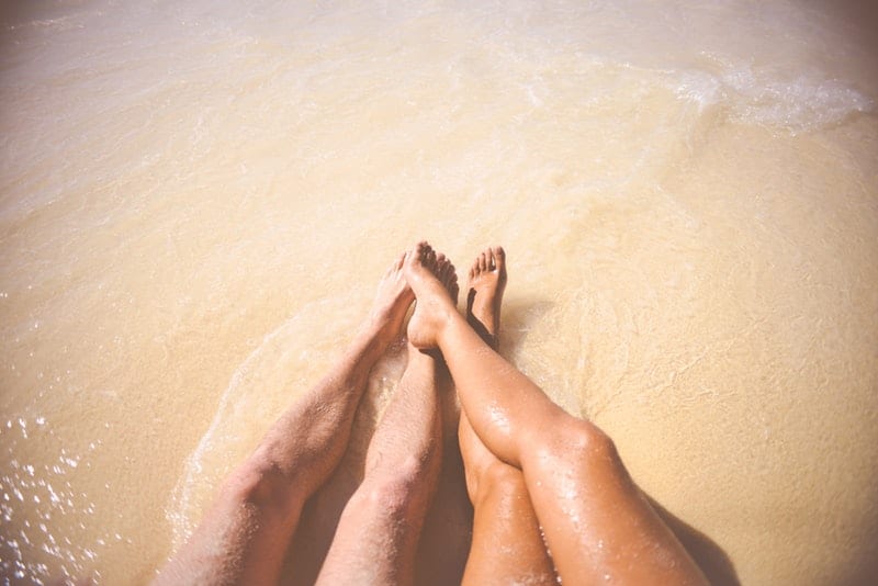 uomo e donna gambe in spiaggia