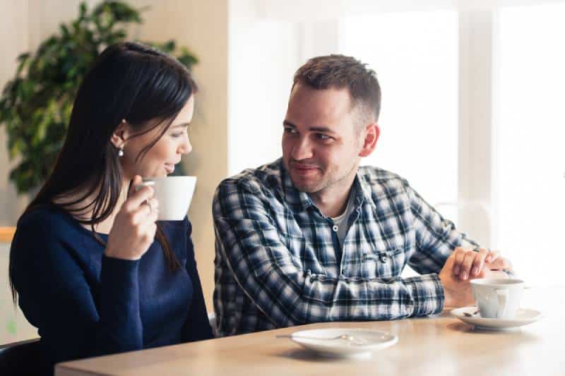 homem e mulher a conversar num café e a beber chá