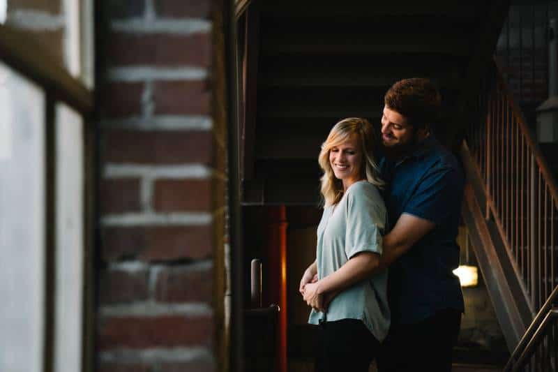 man hugging woman from behind at home