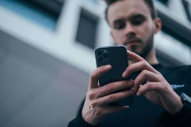 man looking at phone outside