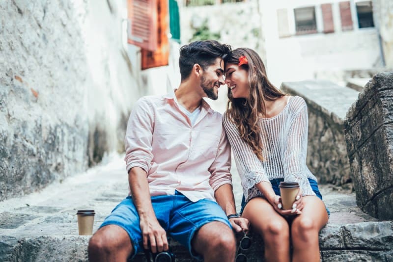 romantic couple sitting on stairs face to face