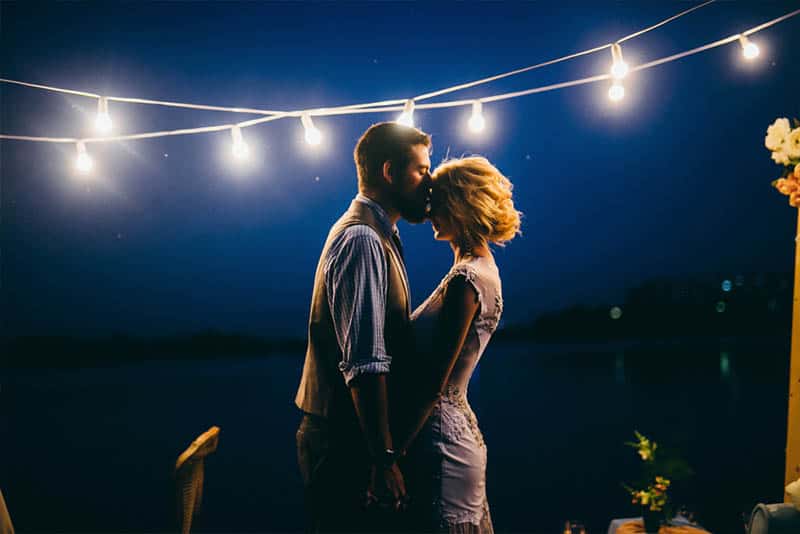 homem romântico beija a testa de uma mulher