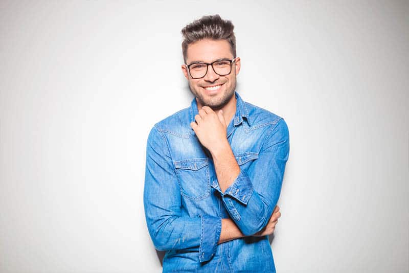 uomo sorridente con occhiali da vista e camicia blu