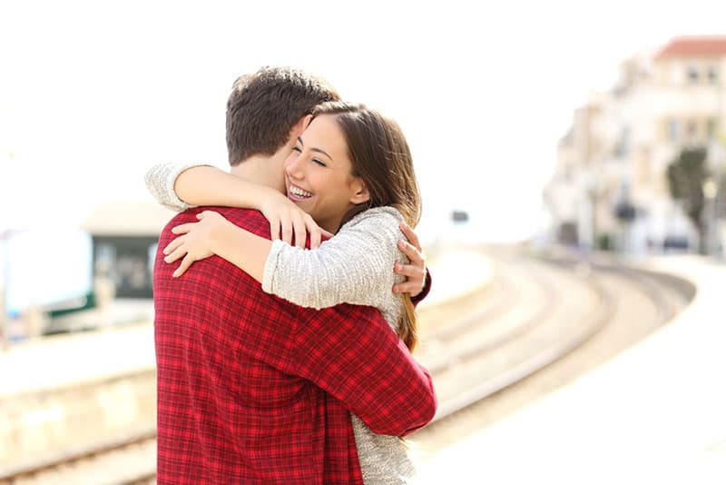 smiling woman hugs man