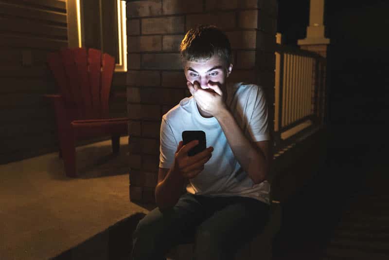 uomo sorpreso che guarda il telefono