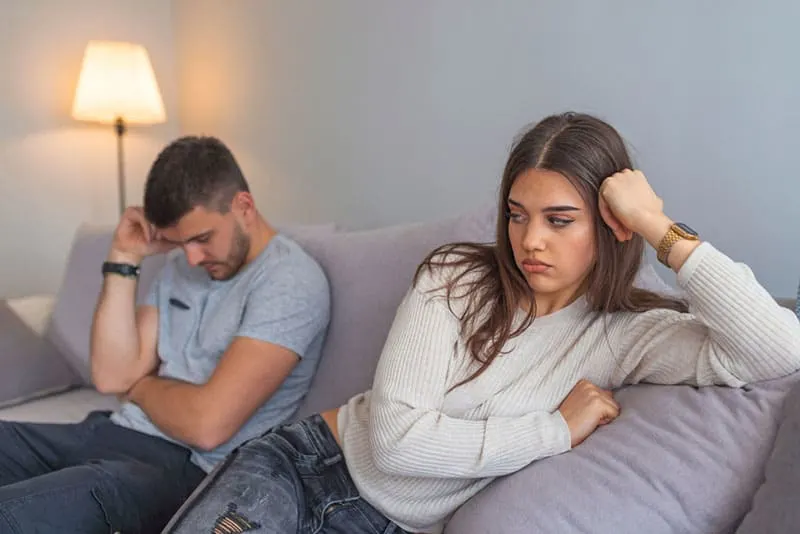 upset couple sitting at living room