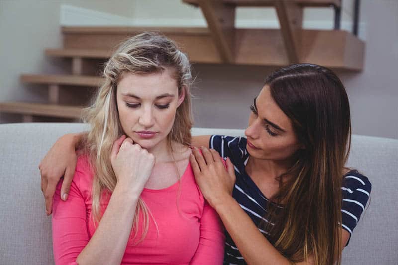 mujer consolando a su amiga