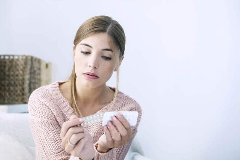 mujer con pastillas en la mano