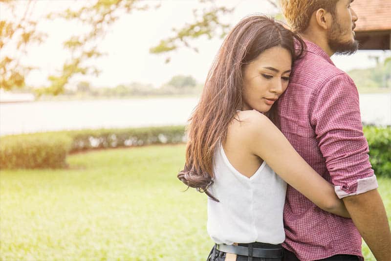 mulher a abraçar um homem nas traseiras do exterior