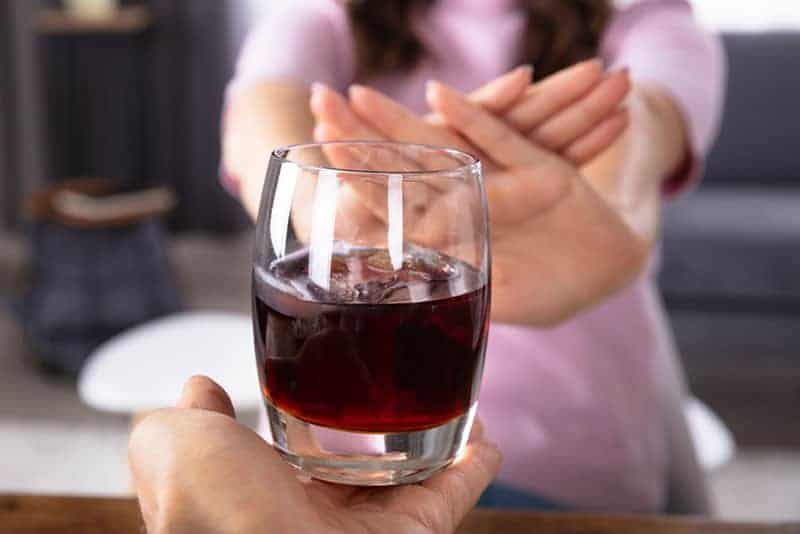 mujer que rechaza una bebida alcohólica