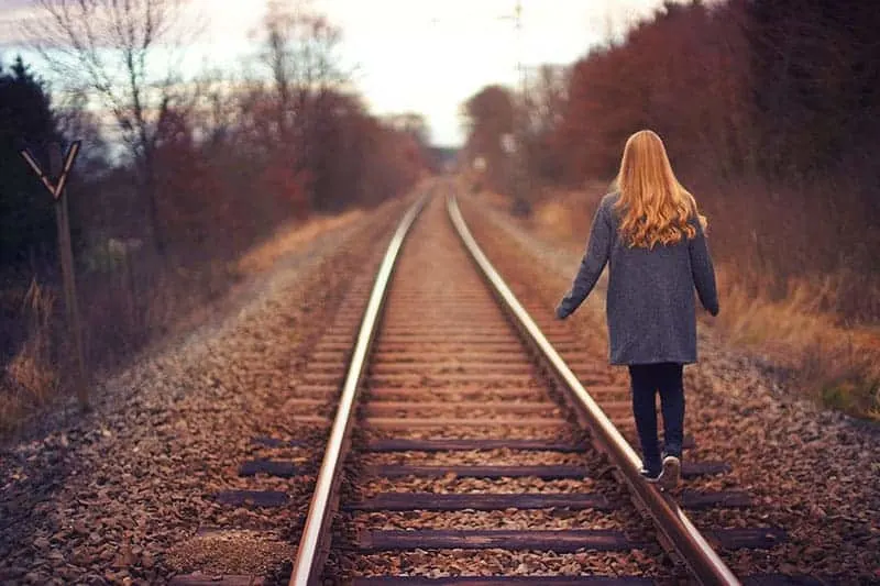 woman walking on the train road