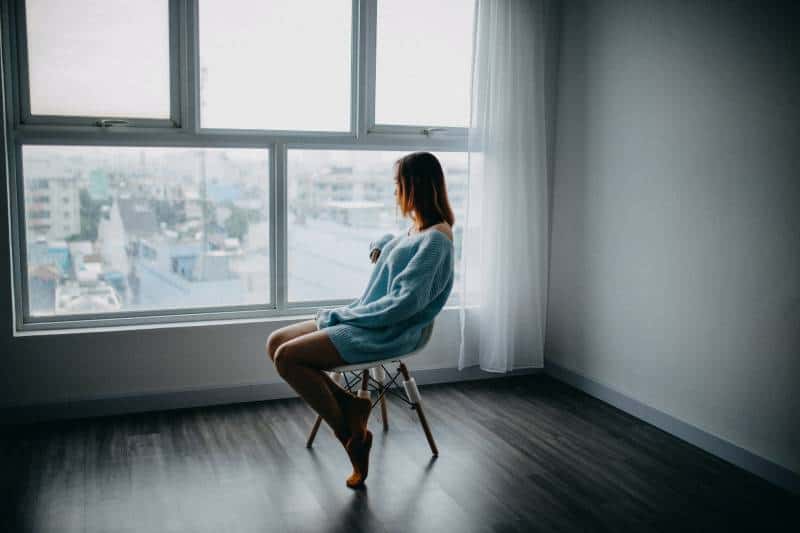 worried woman sitting on chair at home