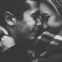 black and white photo of smiling couple hugging