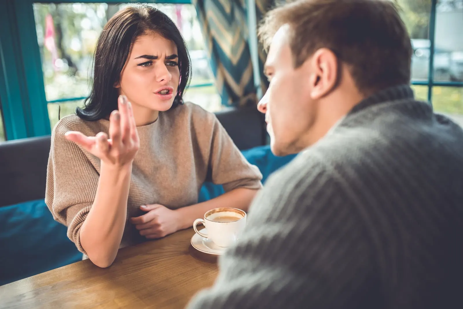 a man and a woman are arguing in a cafe