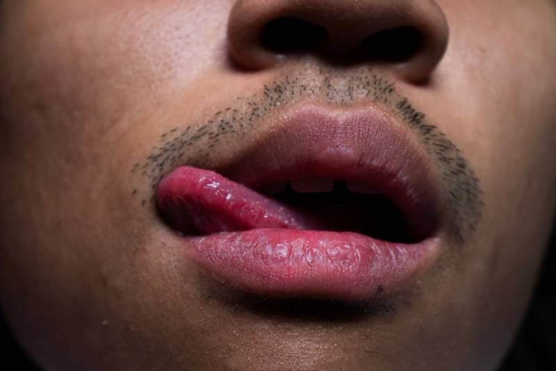 foto ravvicinata di un uomo che si lecca le labbra