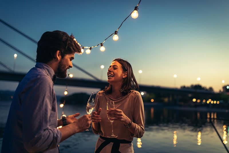 coppia che beve champagne davanti al lago