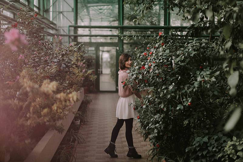 mujer feliz entre plantas