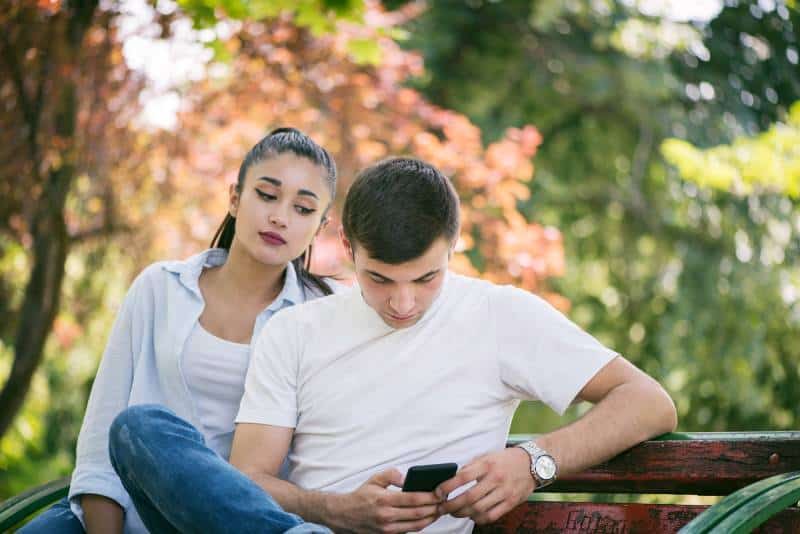 mulher ciumenta a olhar para o telemóvel de um homem