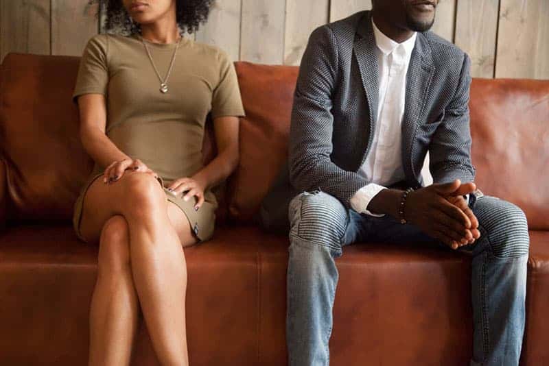 man and woman sitting at sofa, not talking