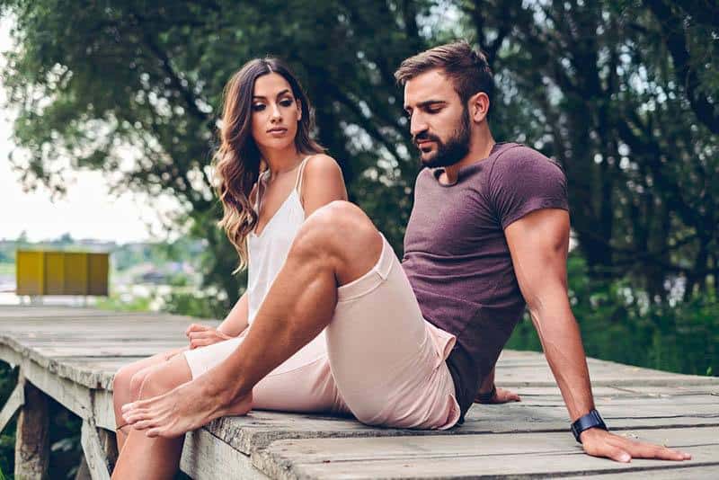 hombre y mujer sentados en el muelle