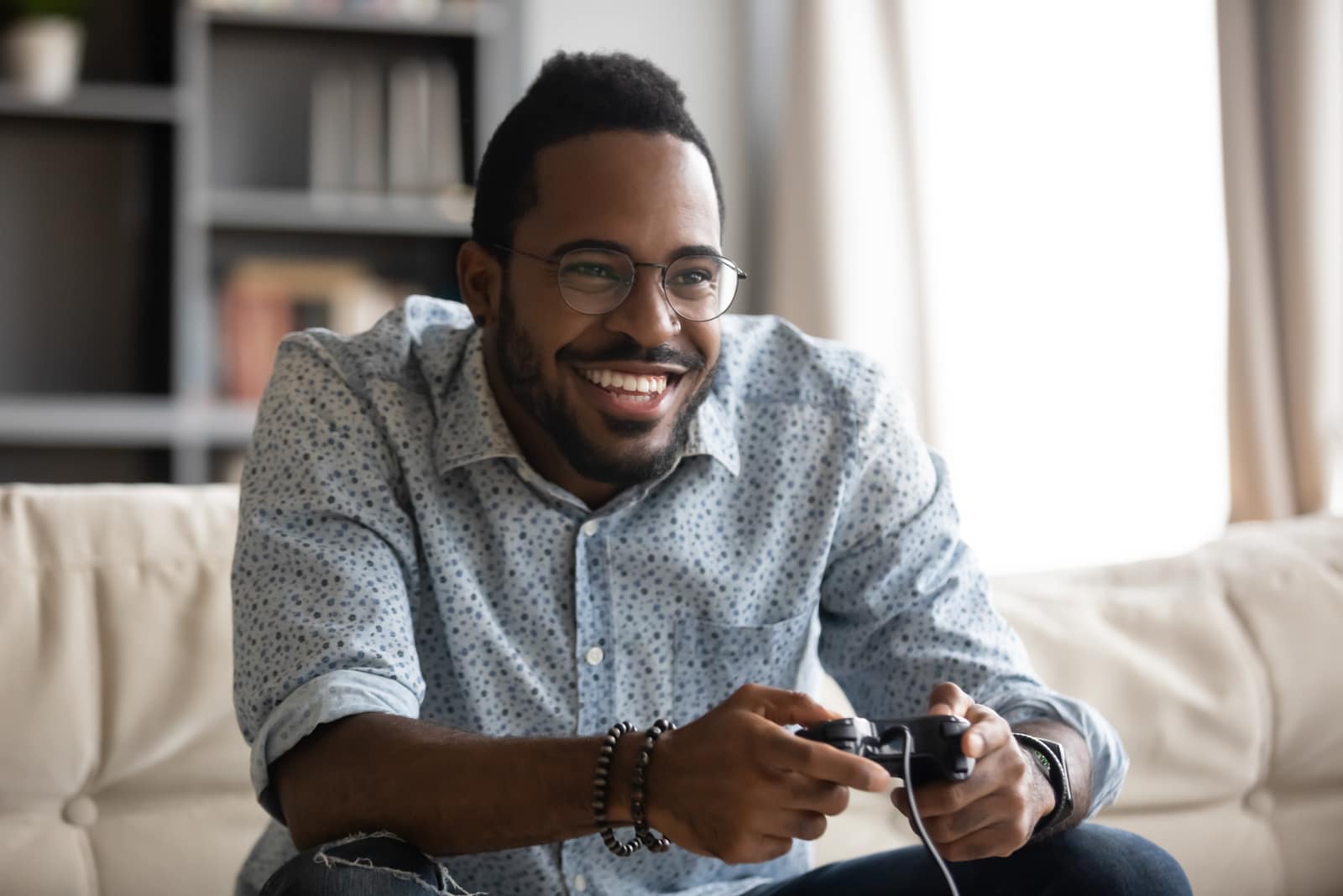 homem negro sorridente joga na consola de jogos