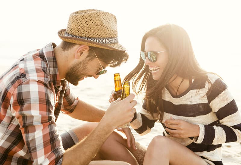 coppia sorridente che beve birra