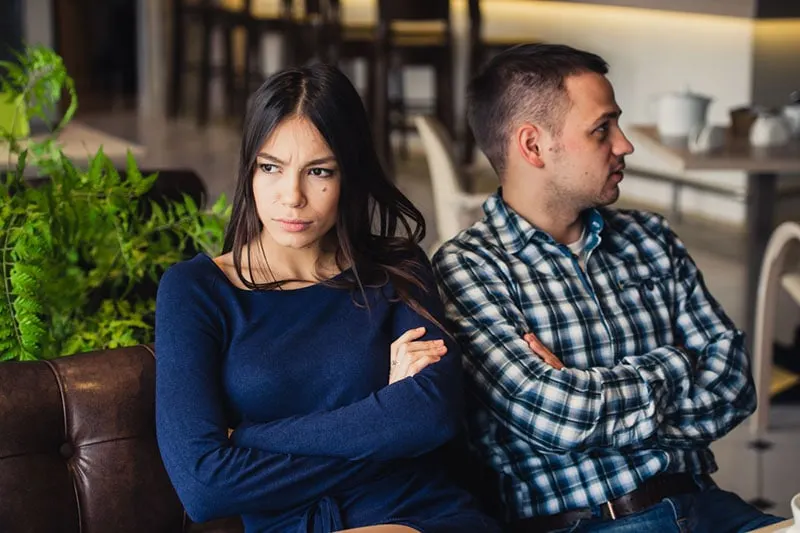 unhappy woman sitting next to boyfriend