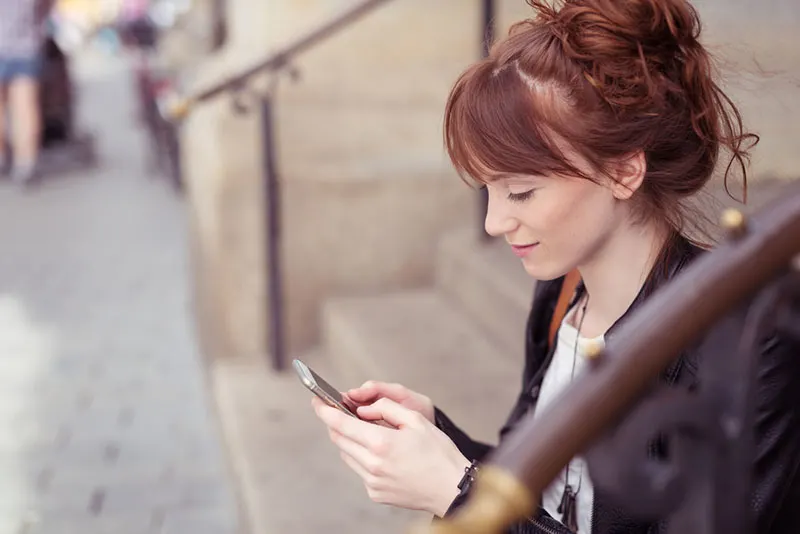 young smiling woman texting