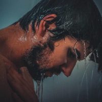 vista laterale del viso di un uomo mentre fa la doccia