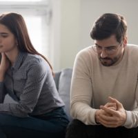 pareja triste sentada en un sofá