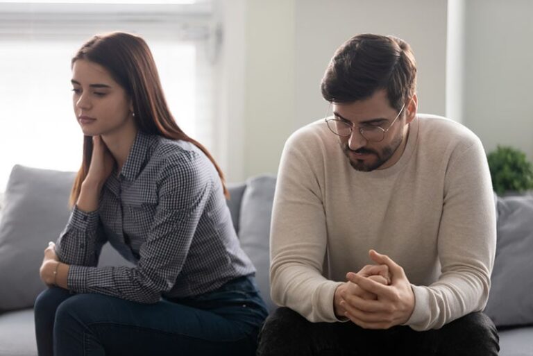 sad couple sitting on sofa