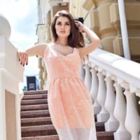 beautiful woman wearing dress and standing on stairs