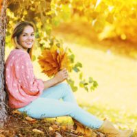 the woman sits with a leaf in her hand