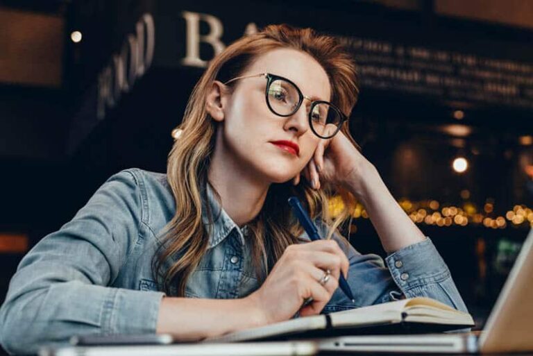 mujer pensativa con gafas en un café