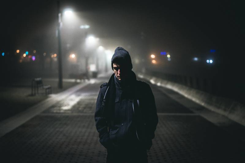 Hombre de pie cerca de farolas durante la noche