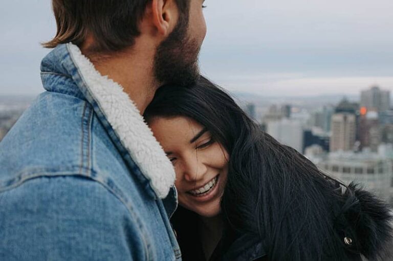 happy loving woman leaning on man chest outside
