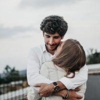 woman kissing man in hug