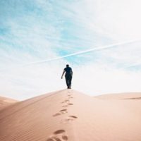 man walking on sands during daytime