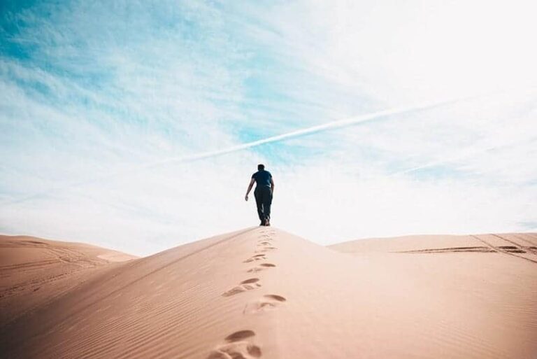 man walking on sands during daytime