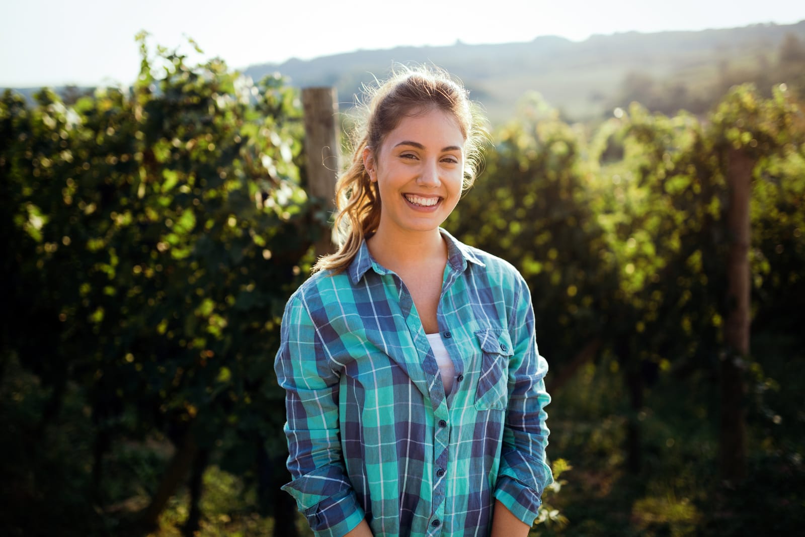 Woman winemaker with grapes in a vineyard