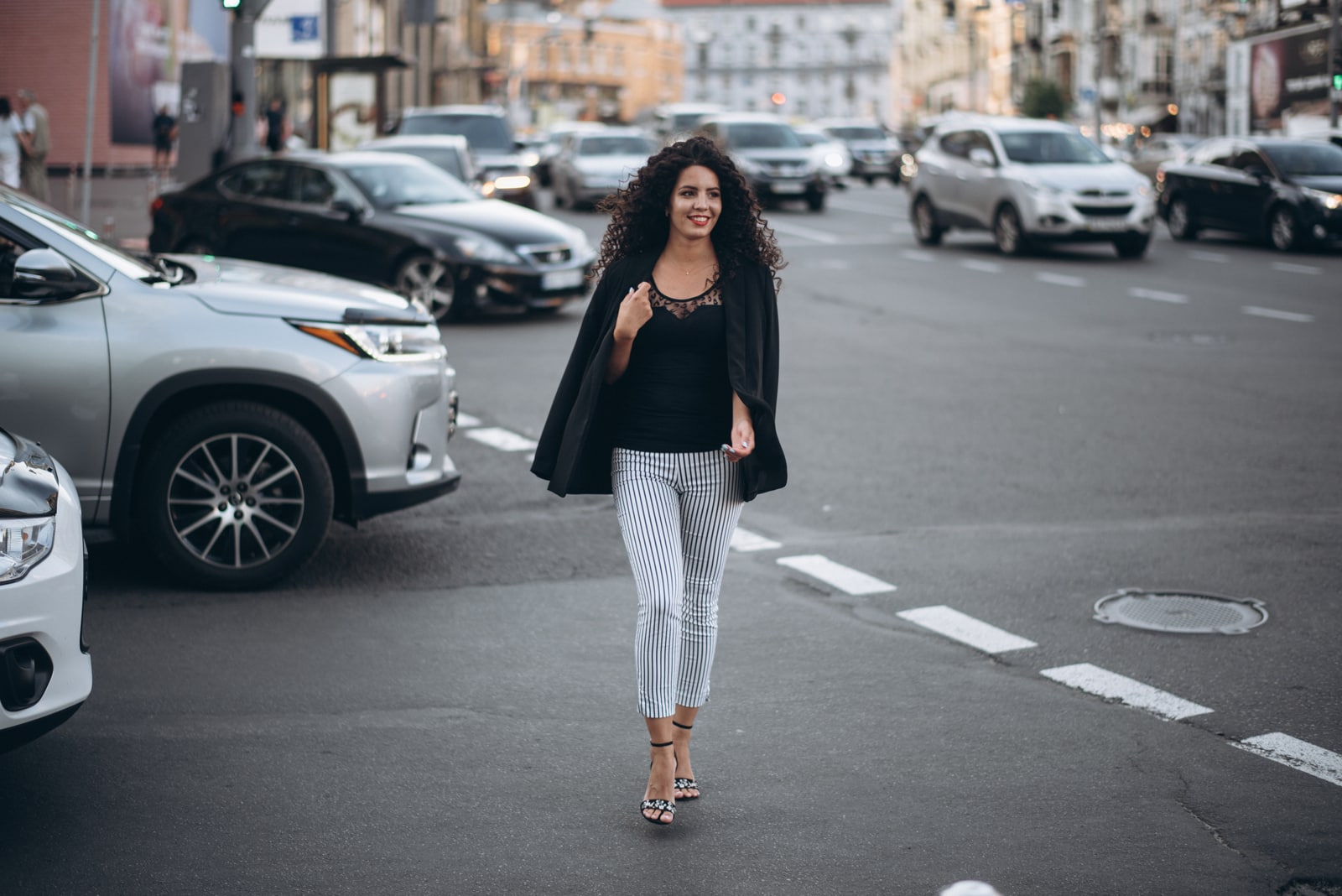 a woman with frizzy hair walks down the street