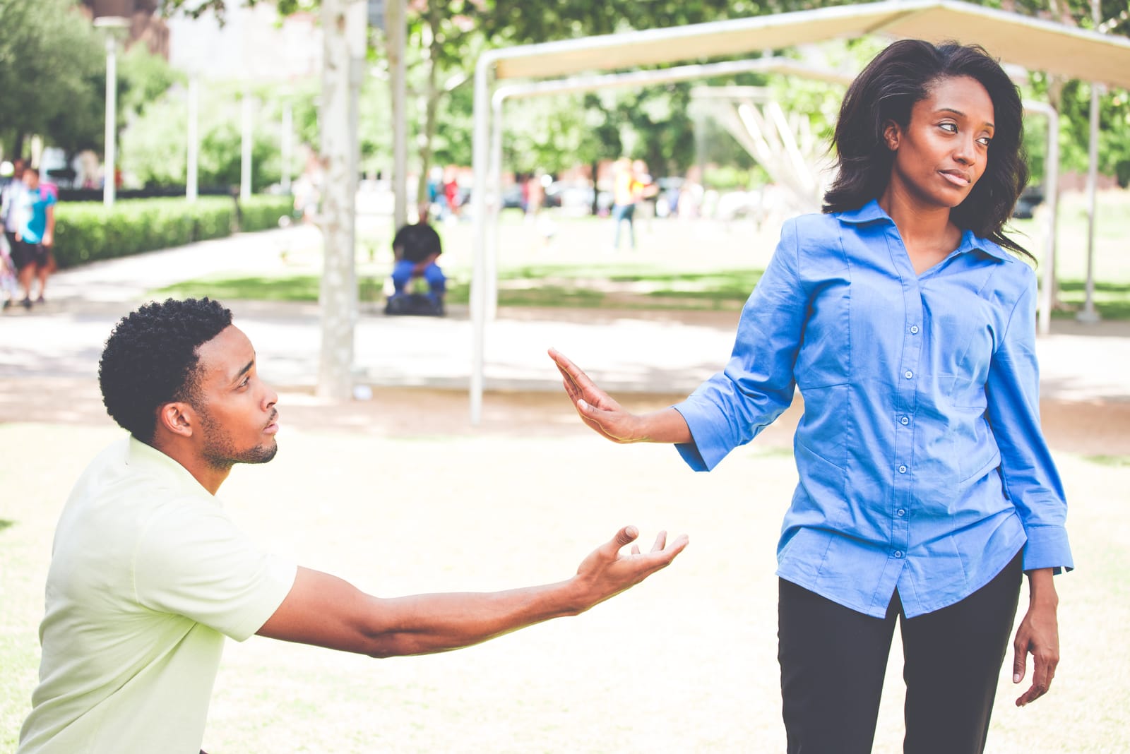 an attractive black woman rejects a man begging her for something