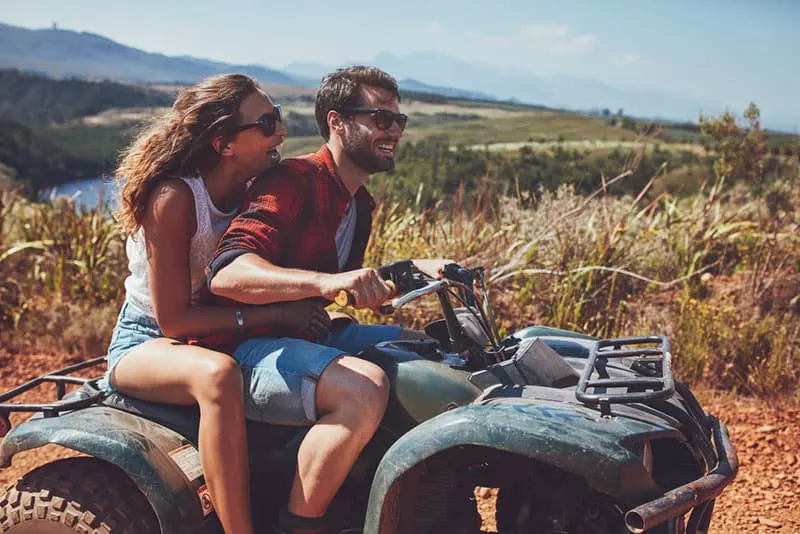 couple riding on a quad bike in nature